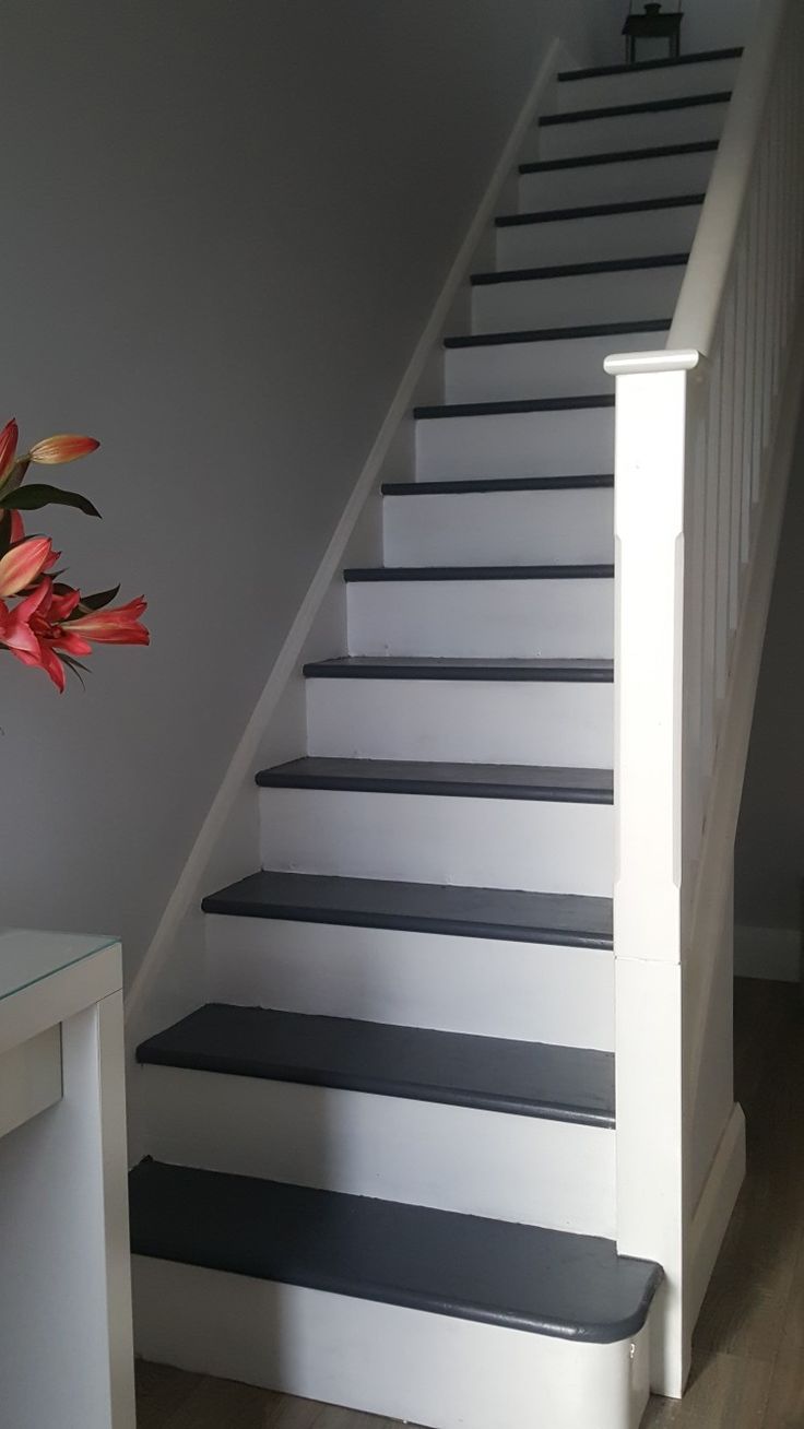 there is a vase with flowers on top of the stairs next to the banister