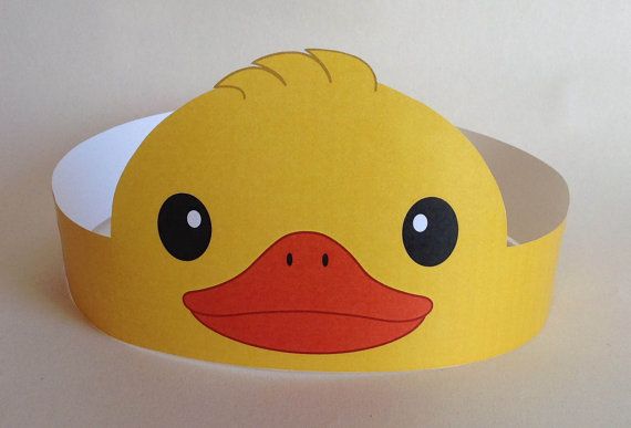 a yellow rubber ducky headband with black eyes and brown beak, sitting on a white surface