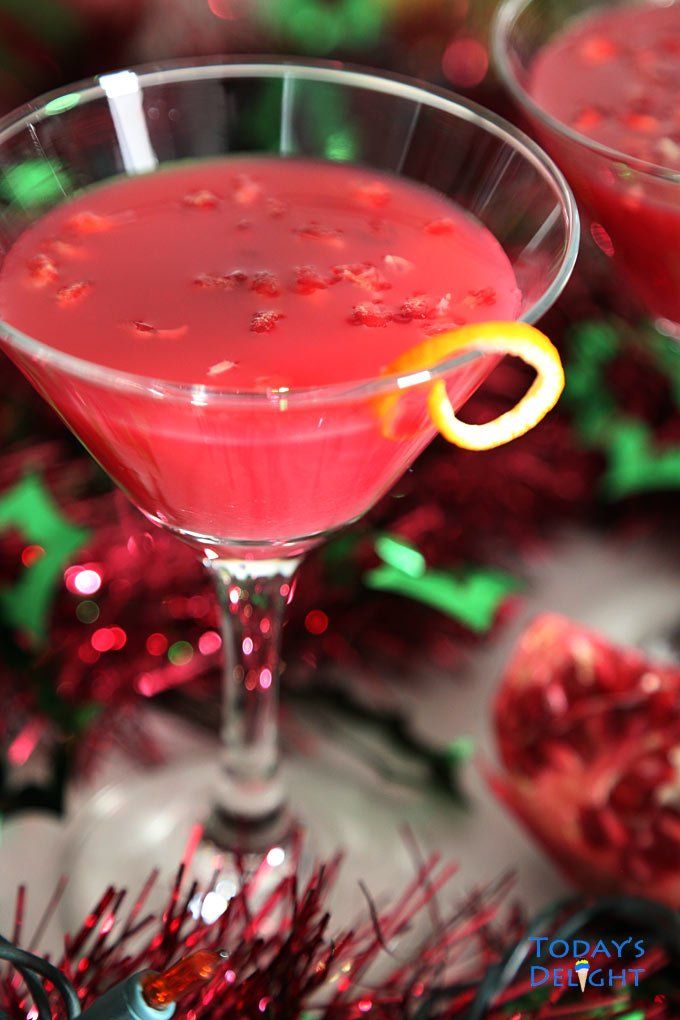 a red drink in a martini glass with an orange garnish