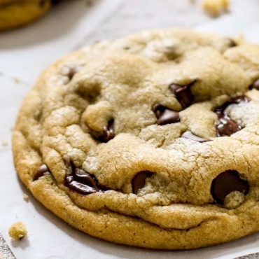 a chocolate chip cookie sitting on top of a piece of paper