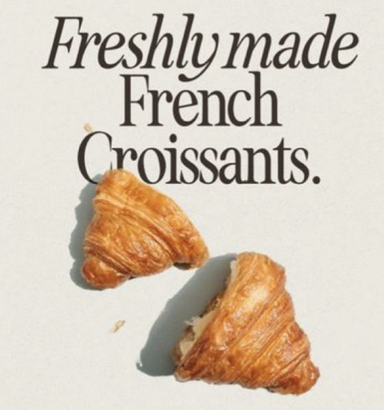 two croissants sitting on top of a white sign that says, freshly made french croissants