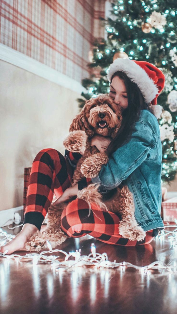 a woman sitting on the floor hugging her dog