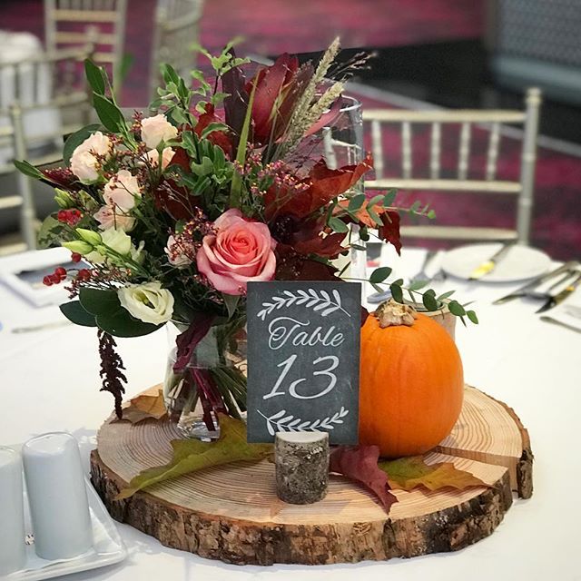 there is a sign that says guest 13 on it next to some flowers and pumpkins