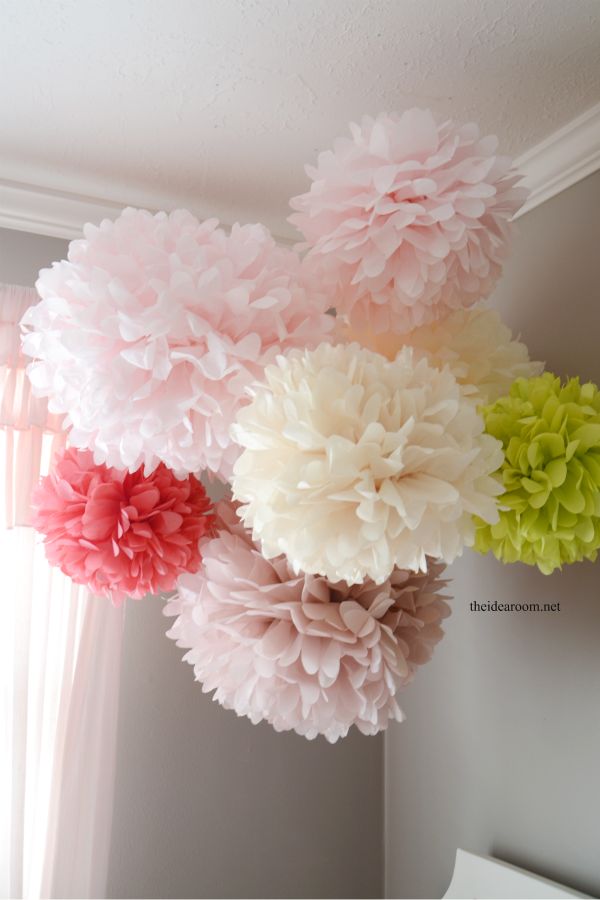 some pink and green flowers hanging from the ceiling in front of a window with an ebay sign below it