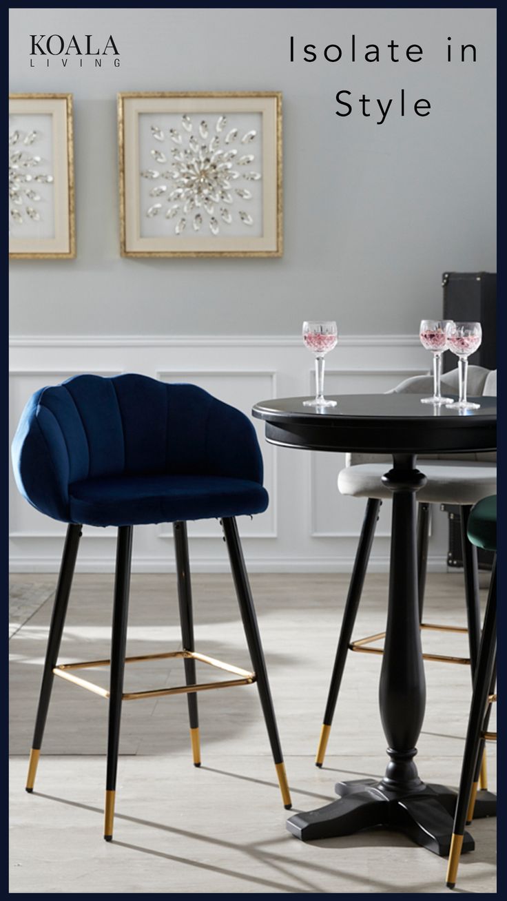 two chairs sitting next to each other in front of a table with wine glasses on it