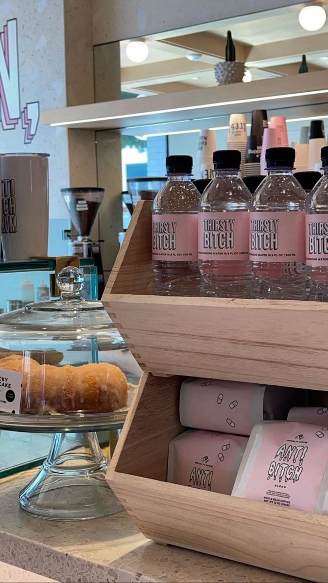 there are many bottles of water and donuts on the counter in front of each other