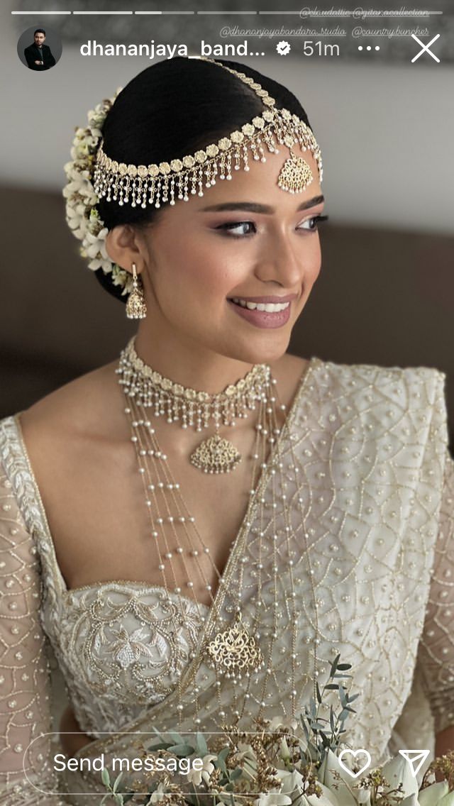 a woman in a bridal gown holding a bouquet of flowers and smiling at the camera