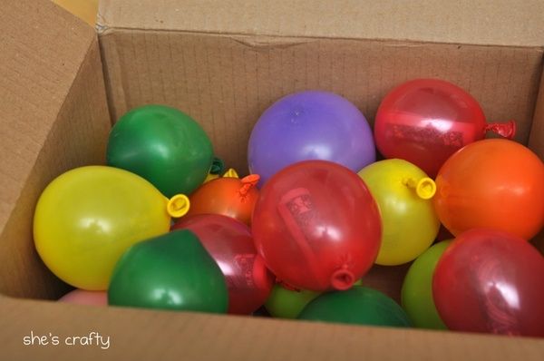 a box filled with lots of colorful balloons in it's cardboard packaging, and the caption reads send a box filled with balloons filled with money and notes for birthday etc