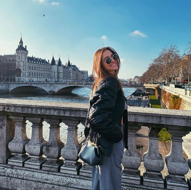 a woman standing on the edge of a bridge