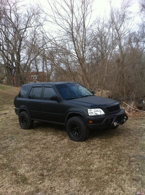 a black suv is parked in the grass