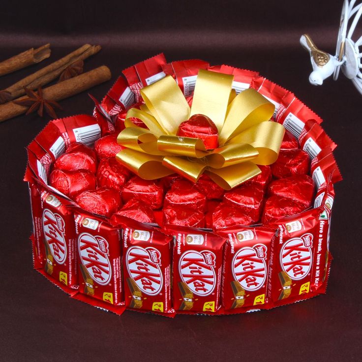 a red box filled with candy and wrapped in gold foil