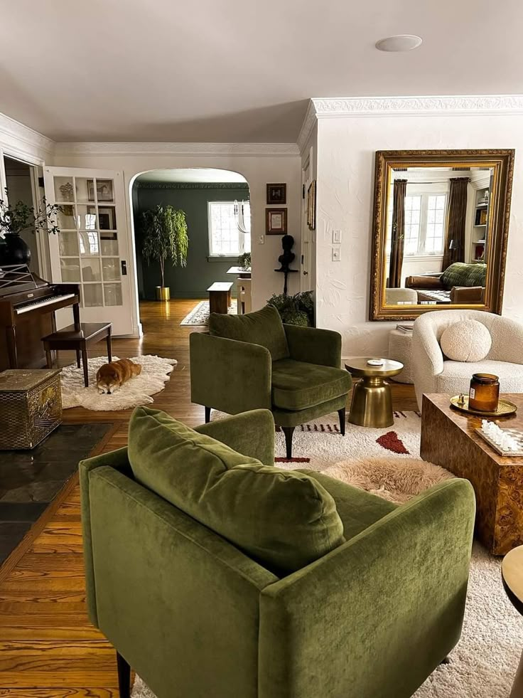 a living room filled with furniture and a mirror on the wall above it's doorway