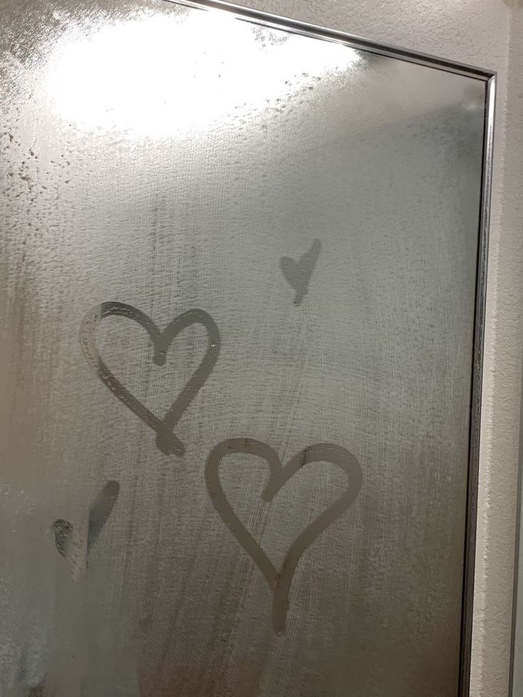 two hearts drawn on a frosted glass door