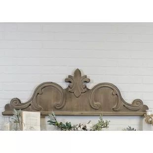 the headboard is made out of wood and has an ornate design