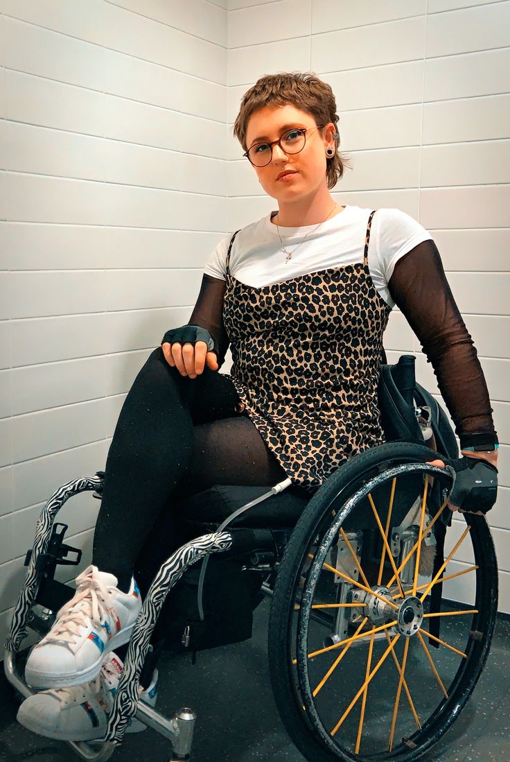 a woman sitting in a wheel chair with her legs crossed and wearing black tights