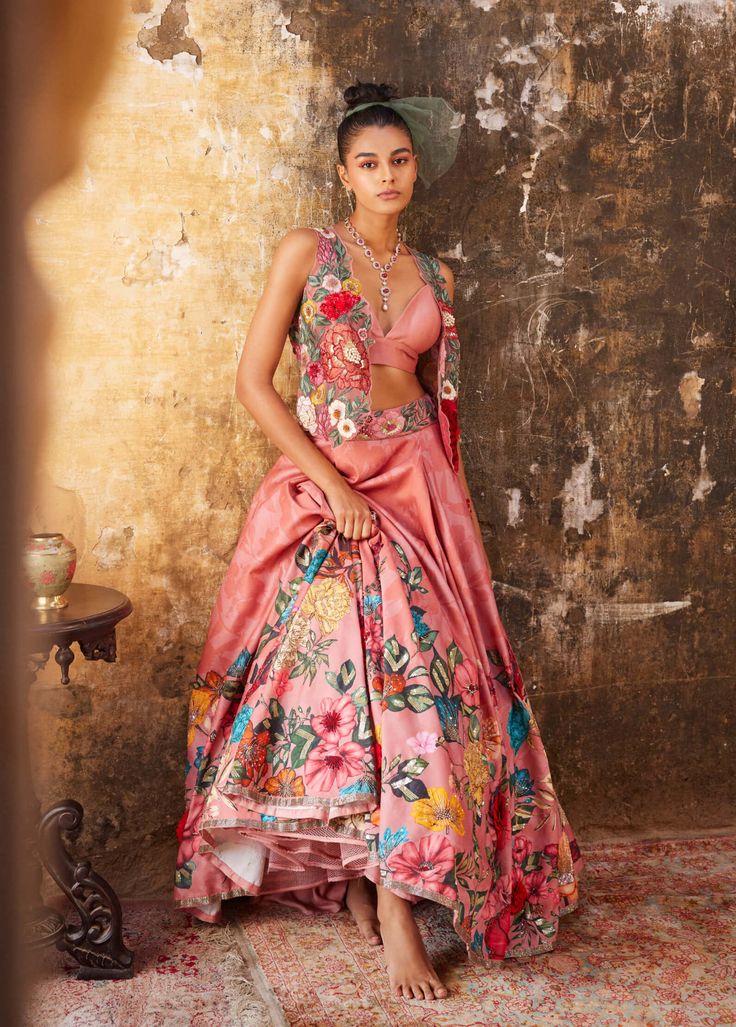 Editor's Note Featuring Varun Bahl's statement gilet set in an old rose base. The set includes a floral embroidered gilet, a tonal bralette & a floral printed lehenga highlighted with sequin, cutdana, beads and 3D hand embroidered flowers. Fabric: Chanderi and mono net Color: Pink Component: Bralette, lehenga & gilet Fit: Fitted at the bust & waist Occasion: Sangeet and engagement Note: Product colour may slightly vary due to photographic lighting sources Care: Dry Clean Only About the Designer Bollywood Style Floral Print Choli For Summer, Fitted Silk Feminine Set, Feminine Fitted Silk Set, Festive Floral Print Sets For Reception, Elegant Designer Choli With Floral Print, Elegant Designer Wear Choli With Floral Print, Silk Sets With Floral Print For Reception, Fitted Floral Print Lehenga For Summer, Silk Floral Print Sets For Reception