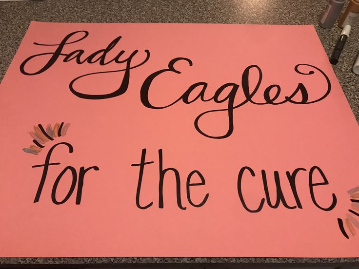 a pink sign that says lady eaggles for the cure on top of a counter