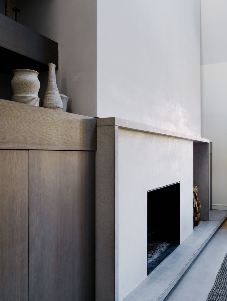 a living room with a fire place next to a wall mounted vase on top of a fireplace