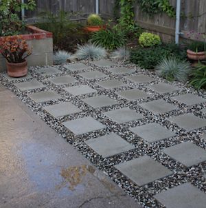 an outdoor patio with potted plants on the side and concrete pavers flooring