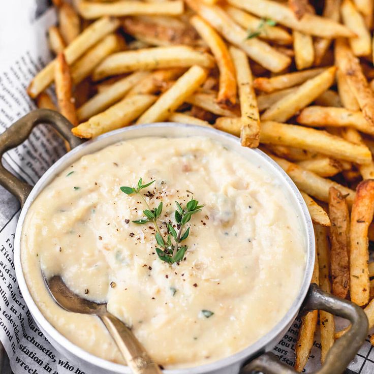 a close up of a plate of food with french fries and dipping sauce on the side