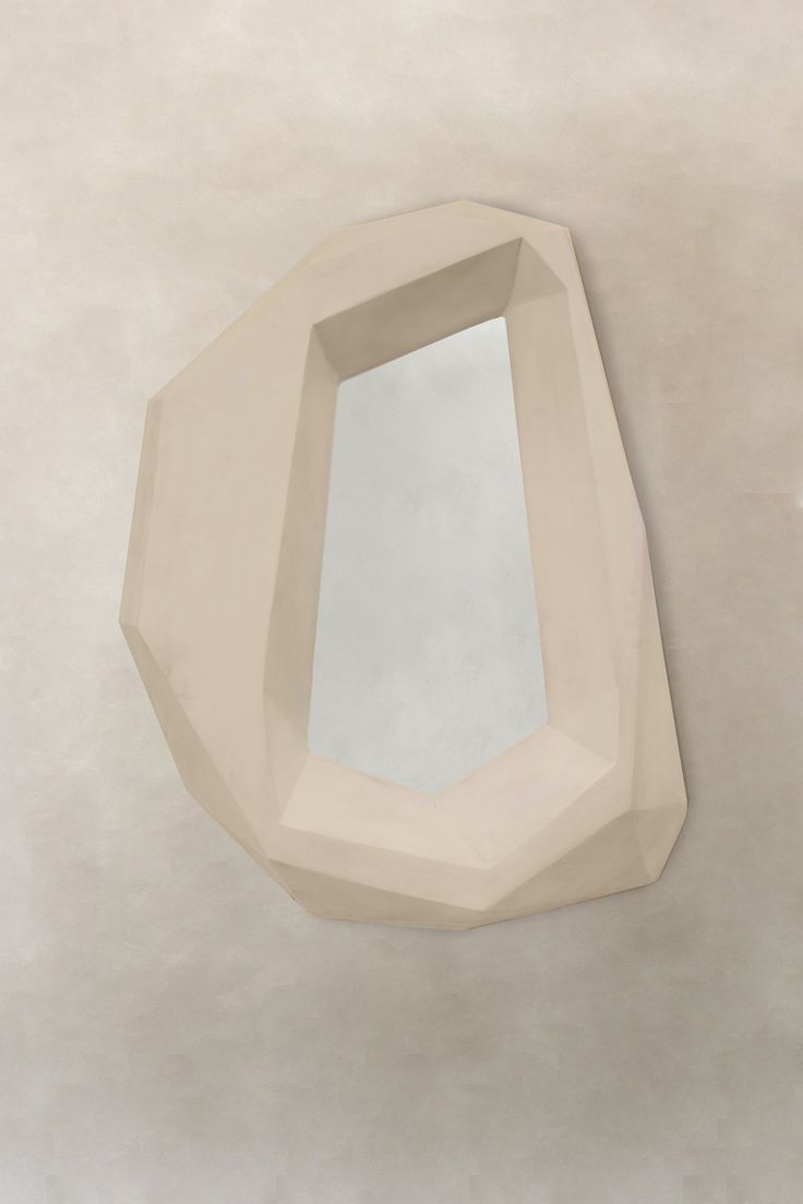 a mirror is hanging on the wall in front of a white stucco wall and ceiling