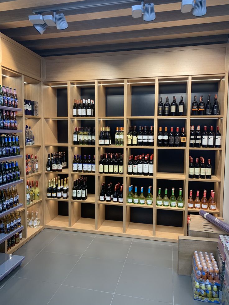 a store filled with lots of bottles of wine on shelves next to a counter top