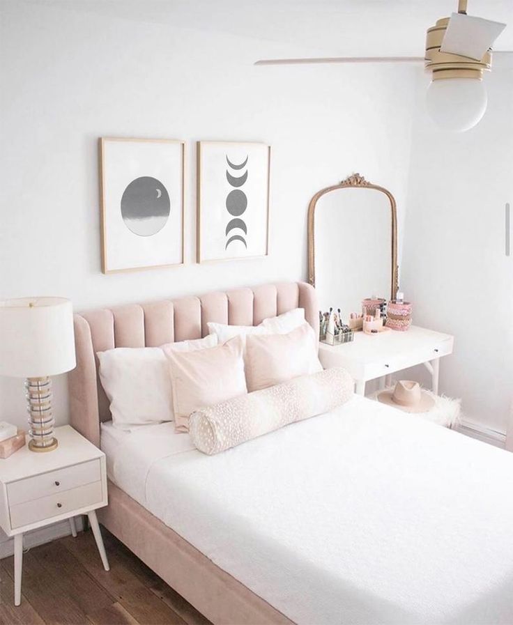 a bedroom with a white bed, pink and gold decor and pictures on the wall