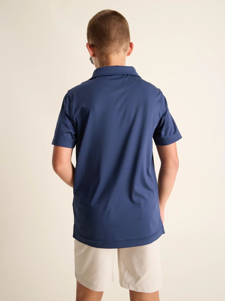 A polo so extremely stretchy and breathable, you’ll wonder how you ever performed without it. Not only does it give you a fresh look that’s perfect for hitting the course or crushing a video call, but it’s also super functional. Made from a lightweight, performance-enhancing fabric that’s anti-bacterial, moisture wicking, UPF 50+ (we’re not done), anti-static, and ultra stretchy. Mix that with a loose fit that can be tucked in or left out, you’ll be Cool and comfortable through whatever life thr Navy Sporty Polo Shirt For Golf, Navy Classic Sports Top, Classic Navy Sports Top, Navy Polo Collar Top For Sports, Navy Moisture-wicking Collared Top, Navy Collared Moisture-wicking Top, Blue Short Sleeve Polo Shirt With 4-way Stretch, Navy Collared Top With Moisture-wicking, Navy Moisture-wicking Collared Polo Shirt