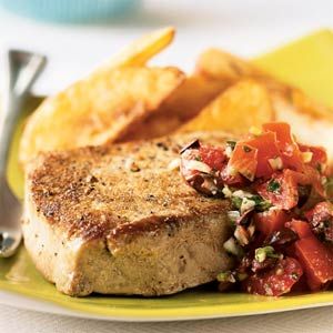 a close up of a plate of food with meat and vegetables on it next to potato wedges