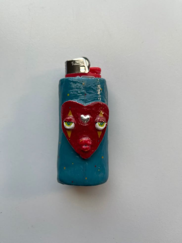 a blue lighter with a red heart on it's side and eyes painted on the front