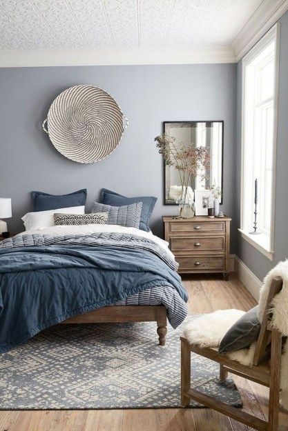 a bedroom with blue walls and wooden floors