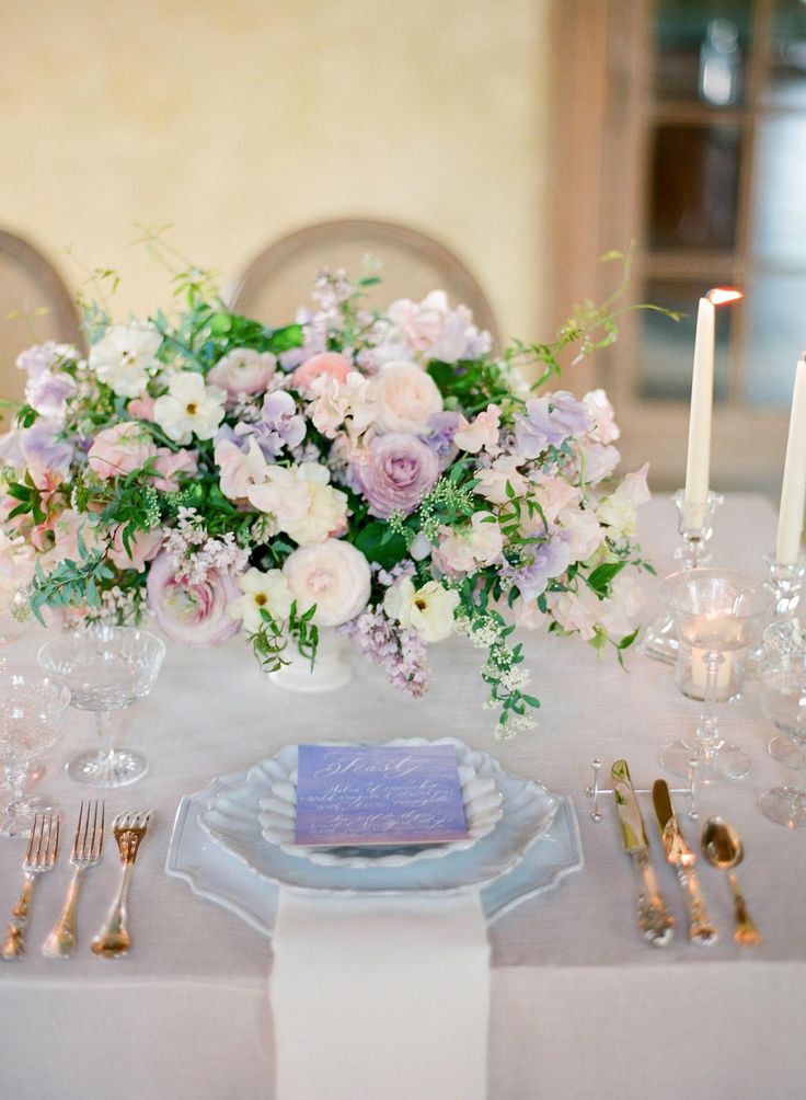 the table is set with silverware, flowers and candles for an elegant wedding reception