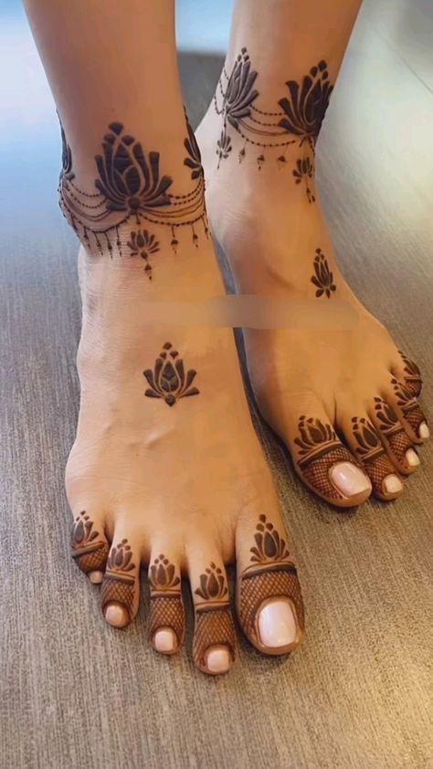 the feet are decorated with henna tattoos and designs on them, as well as flowers