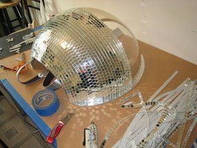 a disco ball sitting on top of a wooden table next to scissors and other items