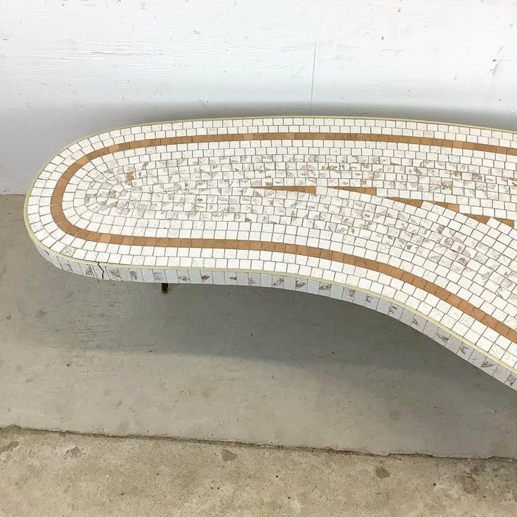 a bench made out of white and brown tiles with words written on the back side