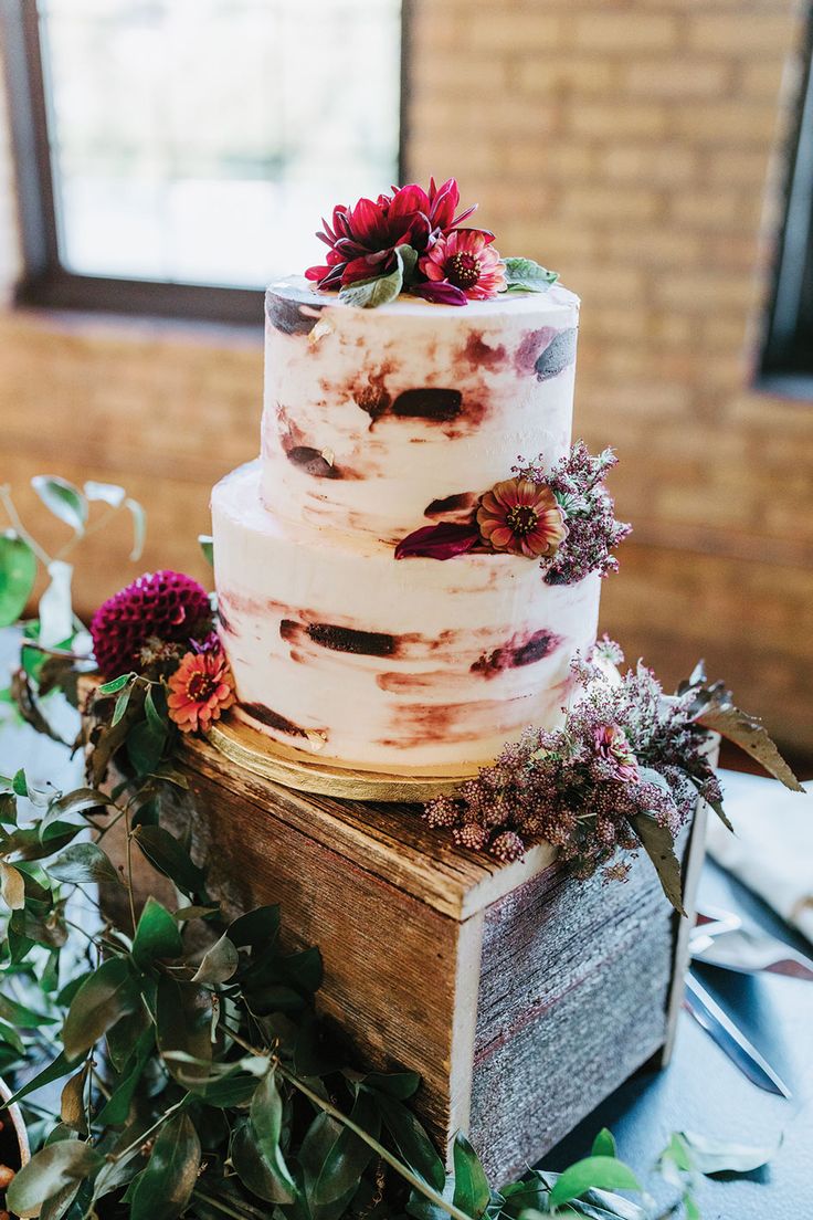 a three tiered cake sitting on top of a wooden box