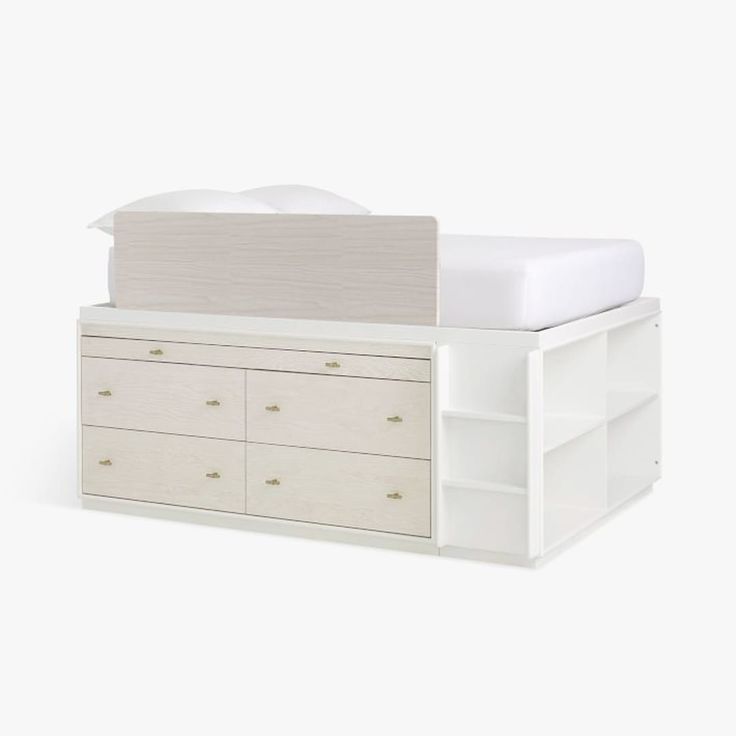 a white bed with drawers underneath it and a mattress on the top of one end