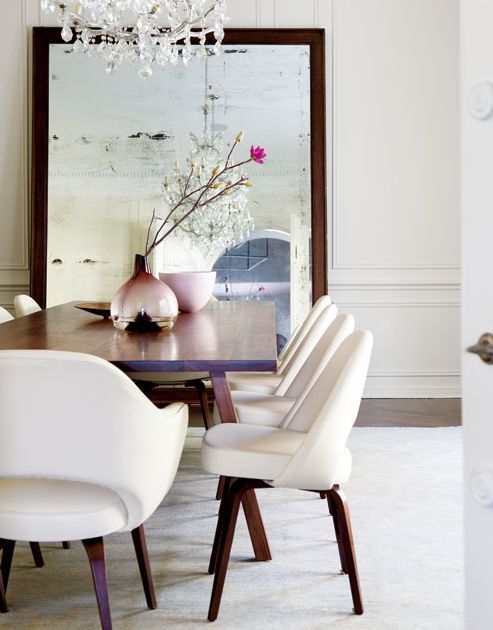 an image of a dining room table with white chairs and a vase on the table