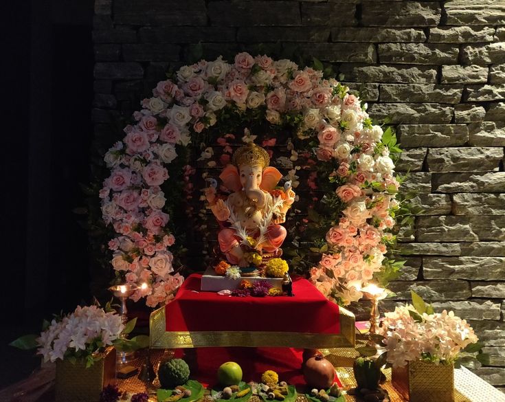 there is a shrine with flowers and candles on the table, surrounded by other decorations