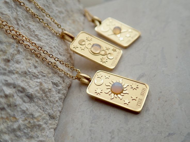 We're so excited to introduce my new line of high quality, anti-tarnish, waterproof jewelry. Thanks to our special plating technique, this celestial beauty is built to last, both pendant and chain are anti tarnish and waterproof. Crafted with hypoallergenic 18k gold stainless steel, it's lead and nickel free and safe and comfortable for sensitive skin. Your choice of pendants feature three of my favorite Major Arcana cards and a sweet little faux opal cabochon for an added touch of mystery. Choo Celestial Pendant Jewelry, Tarnish Resistant, Celestial Pendant Jewelry Tarnish Resistant, Celestial Pendant Jewelry That Is Tarnish Resistant, Mystical Gold Charm Necklace Gift, Celestial Stainless Steel Jewelry For Gifts, Celestial Rectangular Pendant Jewelry Gift, Celestial Style Rectangular Pendant Jewelry Gift, Celestial Style Tarnish Resistant Necklace As Gift, Celestial Silver Tarnish Resistant Charm Necklace