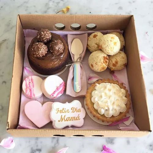 a box filled with lots of different types of cakes and pastries on top of a table