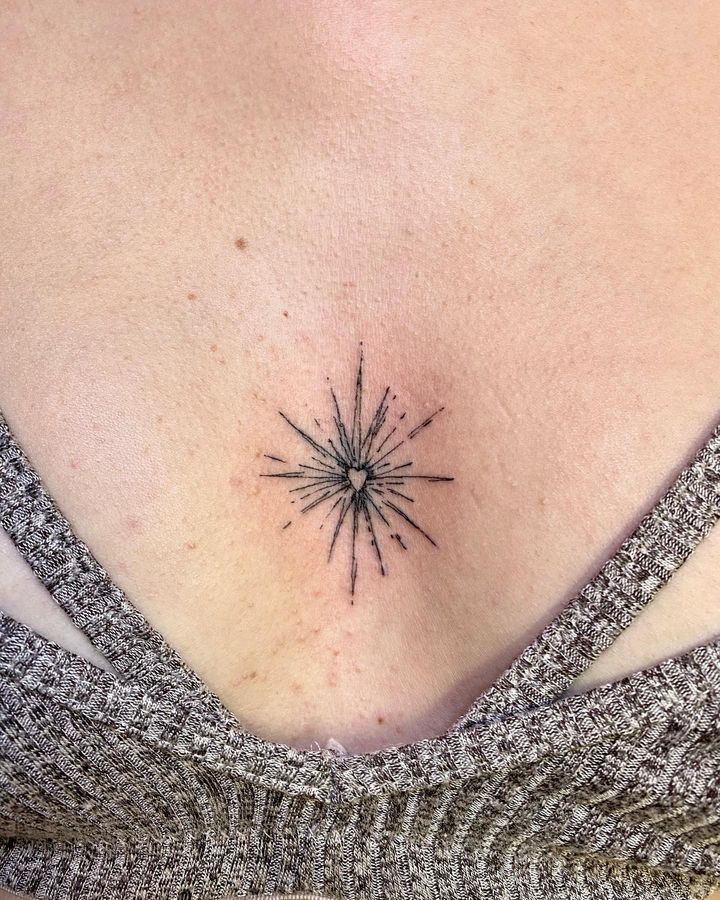 a woman's chest with a small star tattoo on the back of her stomach