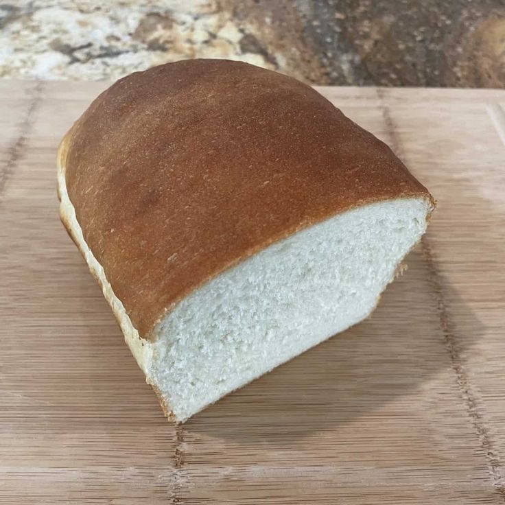 a loaf of bread sitting on top of a wooden cutting board