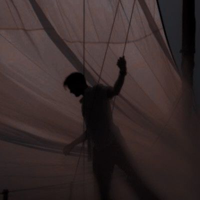 a man standing next to a white sail boat