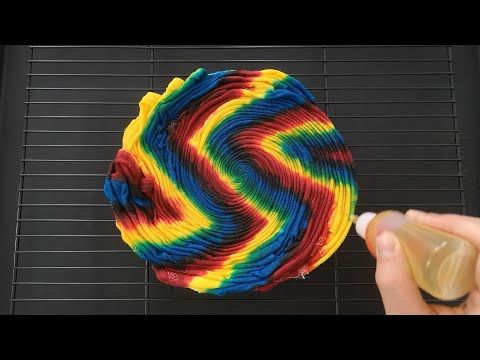 someone is painting a rainbow colored object with yellow and red colors on it's surface