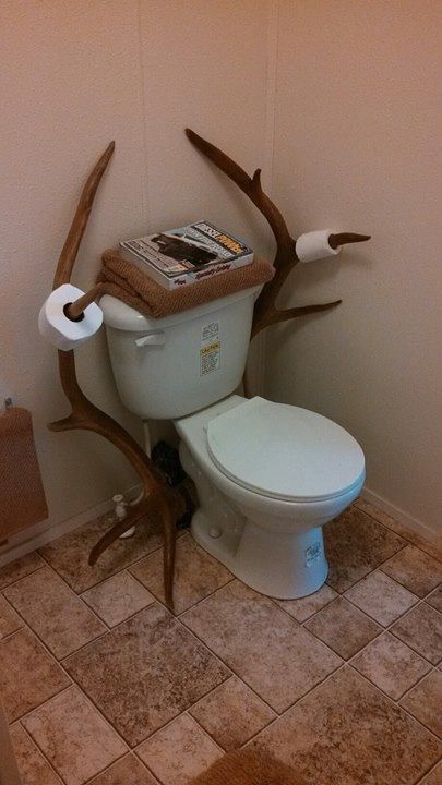 there is a toilet that has some branches on the tank and it's seat up