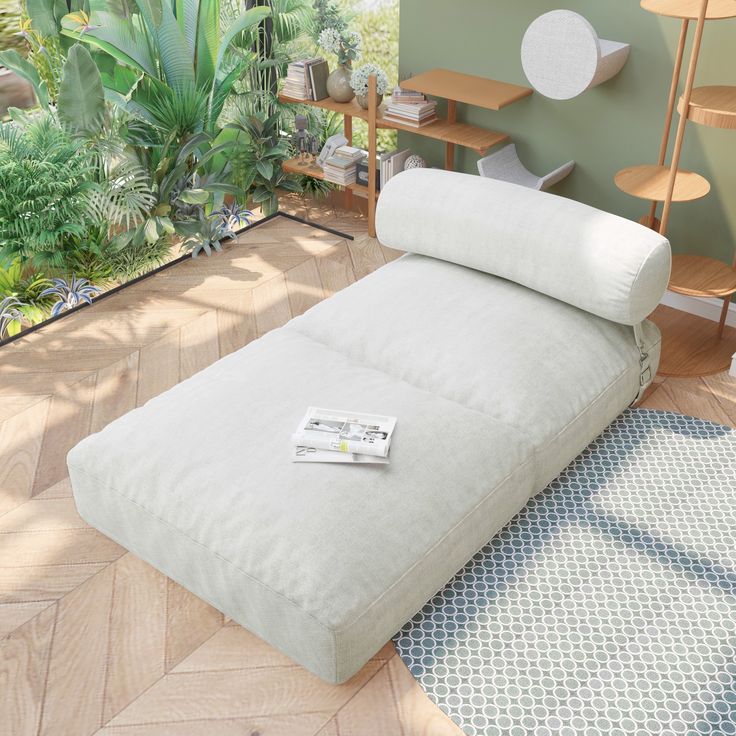 a white bed sitting on top of a hard wood floor next to a green wall