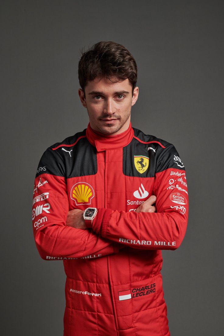 a man in a red racing suit with his arms crossed