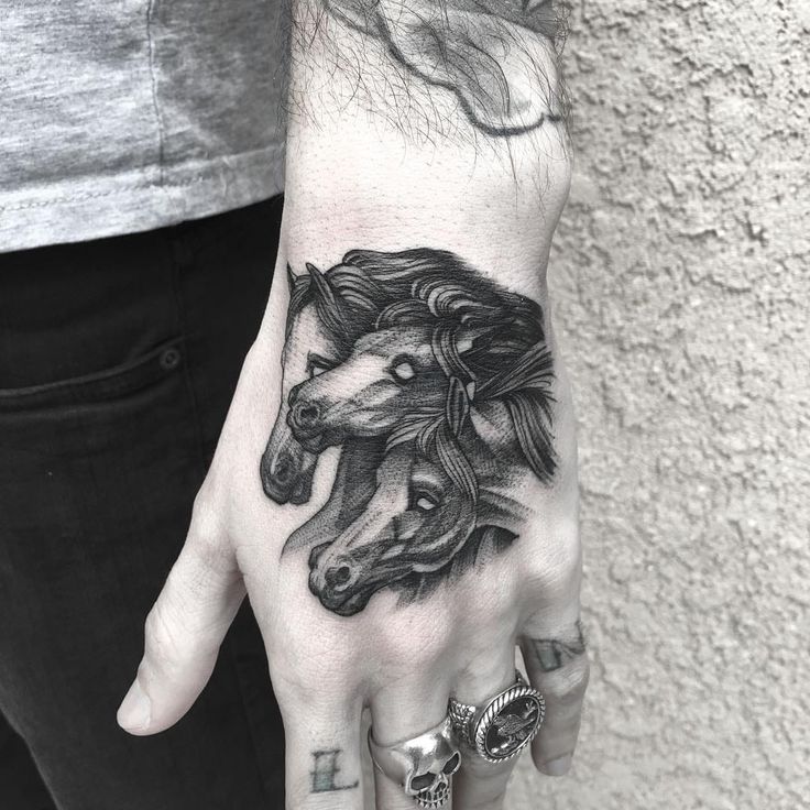 a hand with a horse tattoo on it