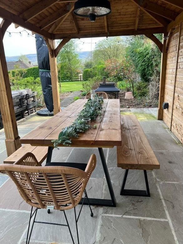 a wooden table sitting under a covered patio